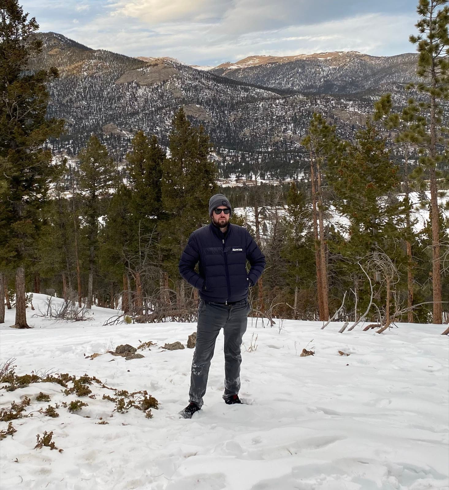 Oliver Edward Locke III, known as Oliver Locke, standing in snow among pines in the mountains